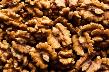 Macro background image of golden roasted walnuts in heap, copy space