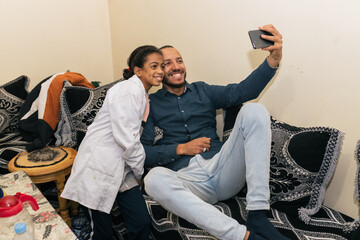 Cheerful ethnic people taking self portrait with smartphone