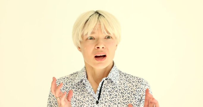 Portrait of young frightened blonde woman on white background 4k movie slow motion. Fear and horror concept