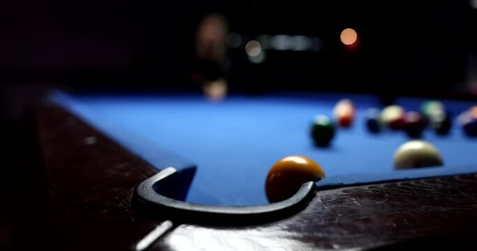 Player hitting ball on table while playing billiards closeup 4k movie slow motion. Entertainment and leisure concept