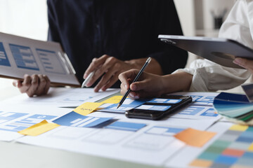 Technology and financial advisory services concept. Business teamwork and working on digital smartphone with ux ui design showing plan at table office. Digital marketing.