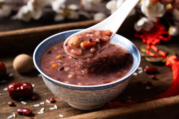  red rice porridge in a bowl. traditional food Laba porridge on table.
