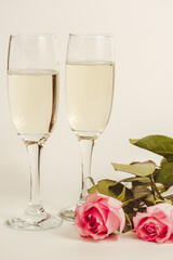 Glasses with sparkling wine on a white background Banner design. Champagne and roses celebrating the holiday