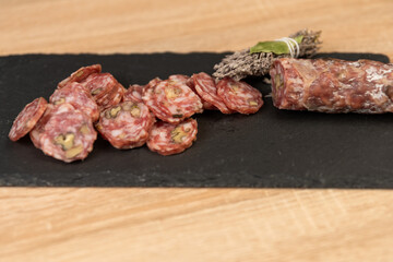 Chorizo ​​sausage and salami, delicate cut. spanish salami on black background with spices, paprika, pepper. Spicy food. red pepper.