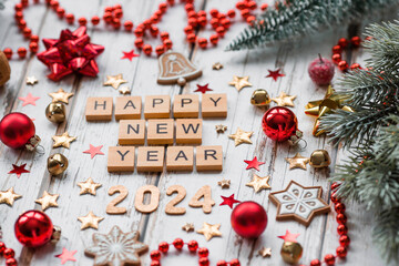 A postcard or banner.A symbol from the number 2024 with red Christmas tree toys, stars, sequins and a beautiful bokeh on a white wooden background. Happy New Year 2024.The concept of the celebration.