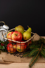 Apples and pears in a metal basket, juicy fruits on the background, fresh and tasty
