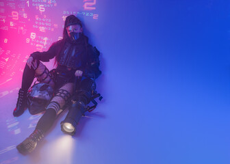 Obraz premium A woman in a futuristic tactical black suit lies on the floor, with a motorcycle helmet and a massive projector lying beside her, against a backdrop of projected digital symbols