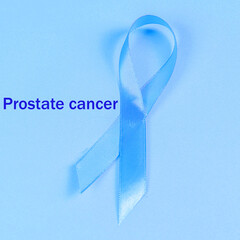 Prostate cancer awareness month ribbon, blue ribbon on blue background, prostate cancer lettering...