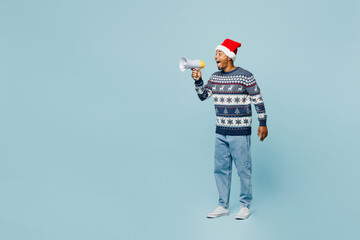 Full body young man wears sweater Santa hat posing scream in megaphone announces discounts sale...