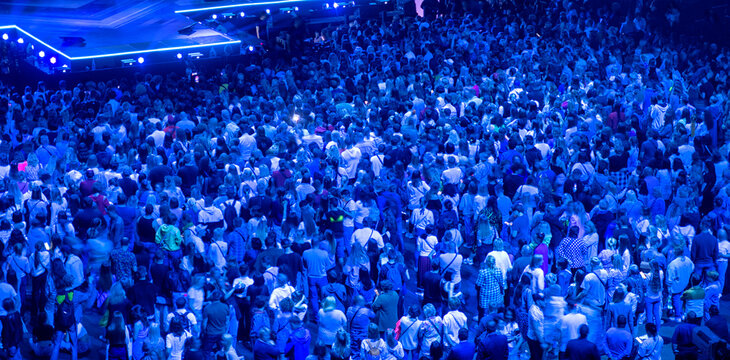 crowd of people at a concert in a huge concert hall