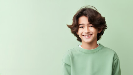 Happy Asian teen boy with brown hair wearing a green sweater