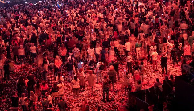 crowd of people at a concert in a huge concert hall
