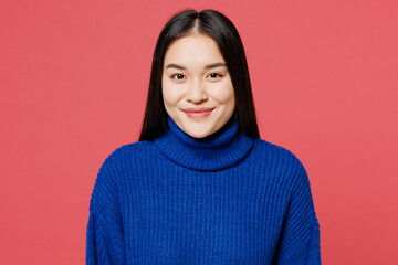 Young cheerful fun cool smiling happy student woman of Asian ethnicity she wear blue sweater casual clothes looking camera isolated on plain pastel pink background studio portrait. Lifestyle concept.
