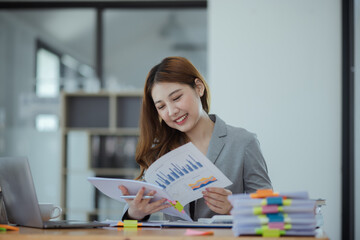 Asian businesswoman discuss new project investment plans and strategies for making business profits with laptop sitting at workplace in modern office.