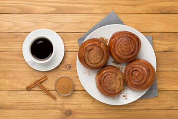 Sweet homemade cinnamon rolls on wooden background, top view