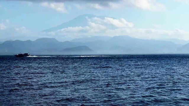 cinematic short A boat is moving in the water with a big mountain in front of it