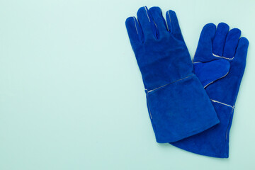 Blue construction gloves on color background, top view