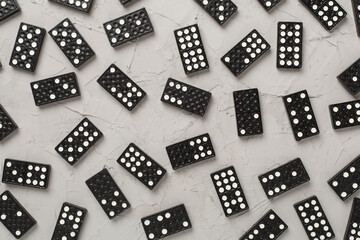 Black domino tiles on concrete background, top view