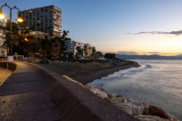 View of promenade and Bajondillo beach in Torremolinos just before sunrise. Costa del Sol, Spain - obrazy, fototapety, plakaty