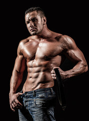 Fototapeta na wymiar Muscular sexy man with torso. Handsome sexual strong man with muscular body. Torso six pack, ab muscle. Leather belt, jeans
