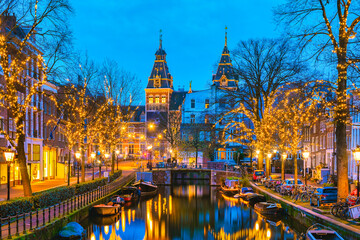 Amsterdam Netherlands canals with Christmas lights during December, canal historical center of Amsterdam at night in December during the Christmas holidays in the Netherlands