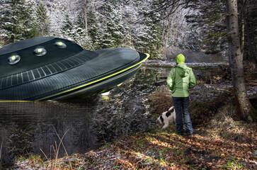Person or child looking at UFO, broken space saucer lies in the water on the banks of a river or...