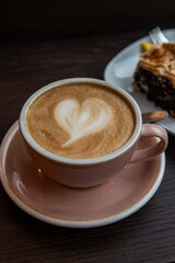 cup of coffee and cake on table in cafe,A cup of coffee with latte art.latte macchiato in a pink cup