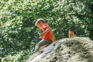 Naklejka na ściany i meble deux enfants jouant sur un rocher, en pleine nature