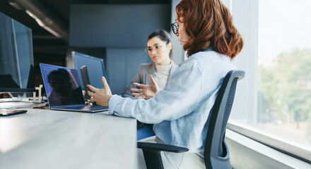Business women coding and collaborating in an office meeting