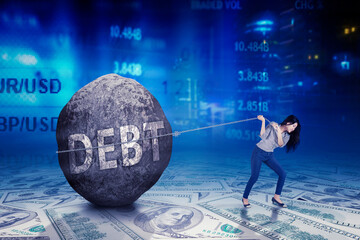Businesswoman pulling a heavy boulder with the word Debt on US Dollars banknotes