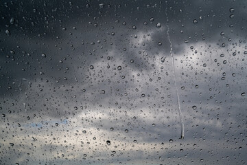Raindrops on the glass against a restless sky.