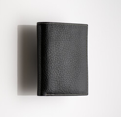 Close-up shot of a fashionable leather men's wallet on a white background with reflection