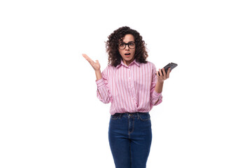 young secretary woman with curly hair in a pink blouse holds a mobile phone in her hand. e-business concept