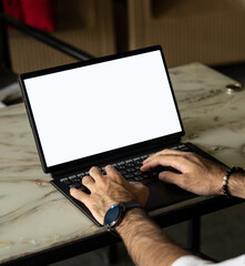 Man using a laptop placed on a stone table. chroma, white screen.