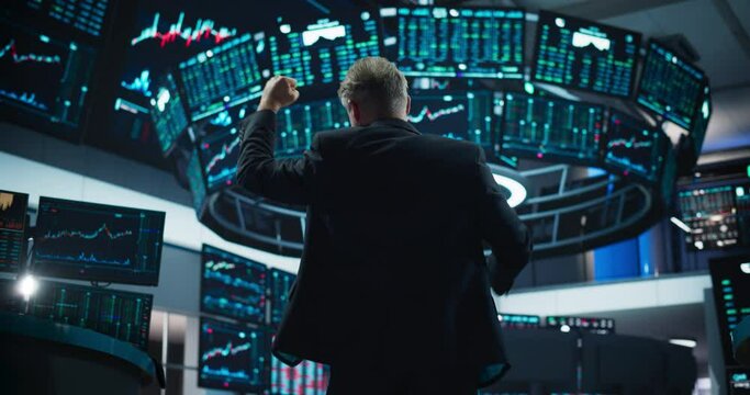 Successful Stock Exchange Trader Celebrating a Profitable Sale. Professional Broker Excited About the Good News, Punches the Air in a Winning Fashion, Showing Positive Emotions. View From the Back