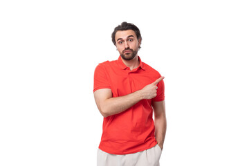 young confident smart 35 year old european man with a styled haircut and beard dressed in a red t-shirt points his finger to the side