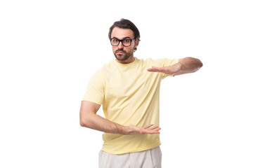 Fototapeta premium young brutal brunette man in a T-shirt on a white background with copy space