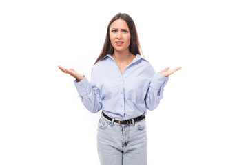 young stylish caucasian model woman with makeup and with dark straight hair dressed in a blue blouse on a white background with copy space
