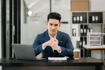 Asian businessman typing laptop and tablet Placed at the table at office