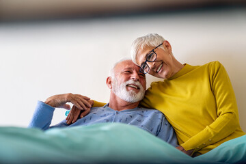Mature couple in love. Happy senior woman visiting her husband in hospital ward.