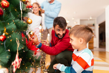 Happy family decorating Christmas tree