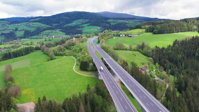 4k Aerial view of the autobahn, moving cars. Countryside summer road in Austria. Transportation cargo delivery. Tracking shot.
