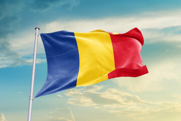Romania national flag waving in beautiful sky. The symbol of the state on wavy silk fabric.