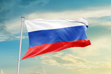 Russia national flag waving in beautiful sky. The symbol of the state on wavy silk fabric.