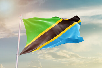 Tanzania national flag waving in beautiful sky. The symbol of the state on wavy silk fabric.