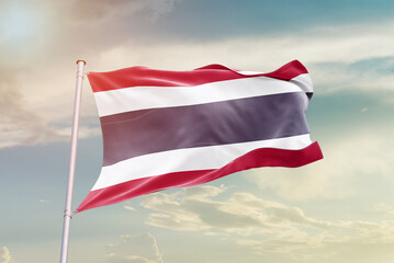 Thailand national flag waving in beautiful sky. The symbol of the state on wavy silk fabric.