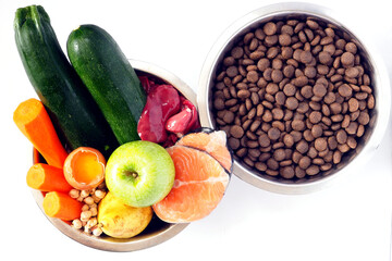 Diet Barf of Natural Ingredients VS dry food in metal bowls. Flat lay