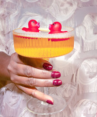 African American Female Holding a Champagne Cocktail with Two Twin Red Rubber Duckies