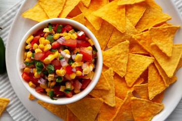 Homemade Corn Salsa with Tortilla Chips on a Plate, top view. Overhead, from above, flat lay. Close-up.