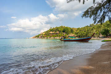 Boat on empty calm sandy tropical Sairee beach in the morning on Koh Tao island in Thailand. Picturesque peaceful calm shore with copy space